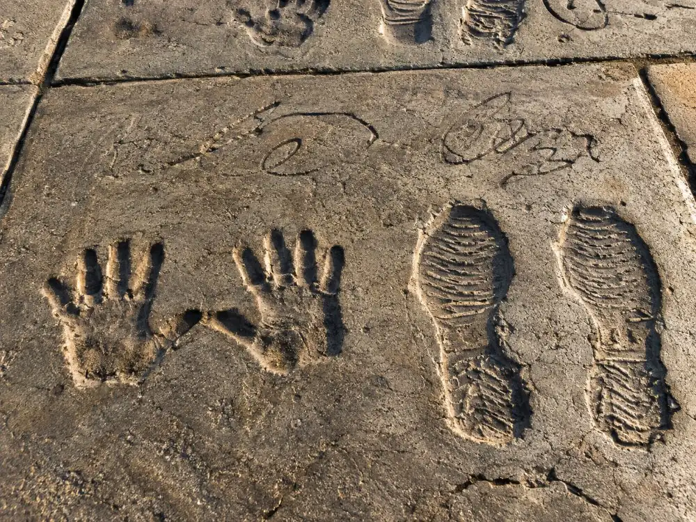 Handprints and footprints pressed into a concrete forecourt slab