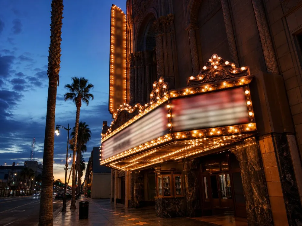 The lit marquee of a historic movie palace on the boulevard